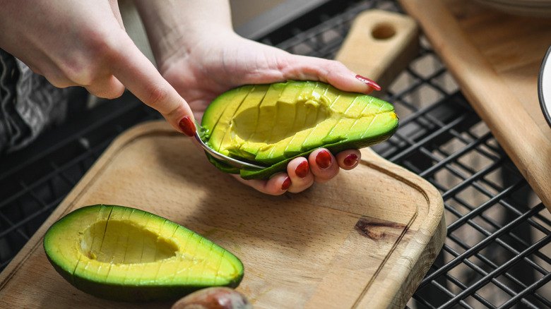 Scooping interior of cut avocado