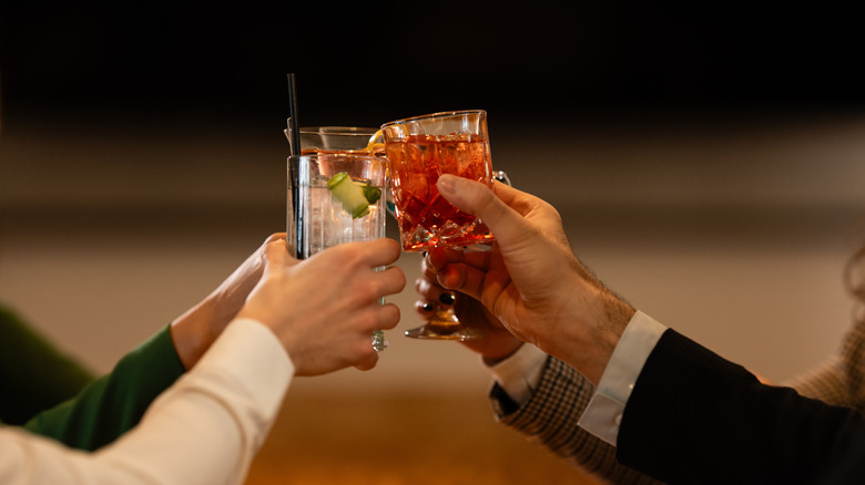 Hands holding up gin-based drinks