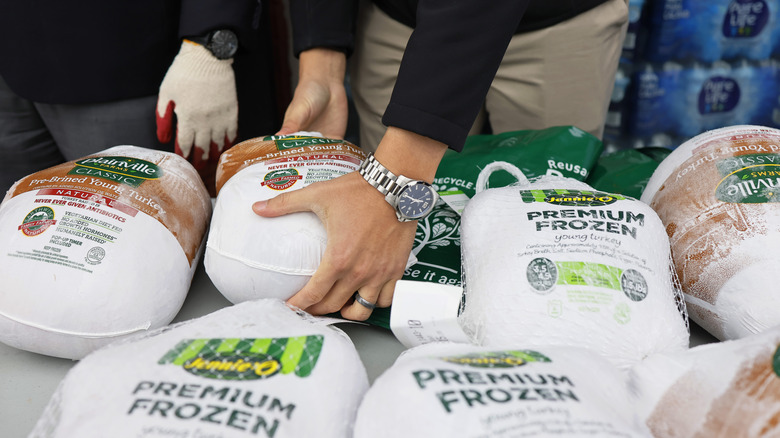volunteers handing out frozen turkeys