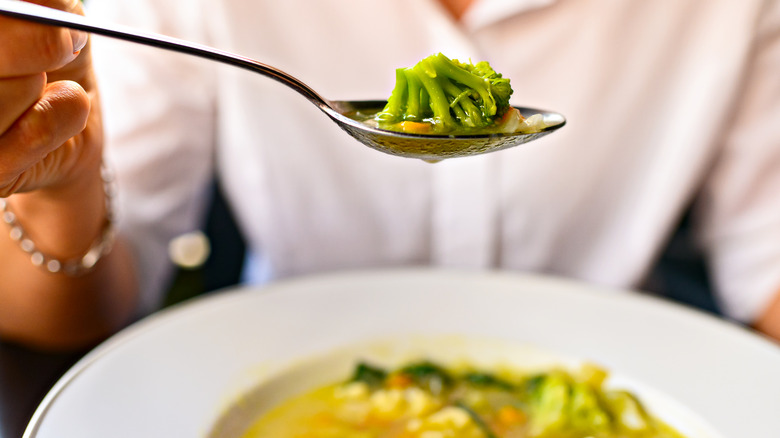 person eating broccoli vegetable soup 