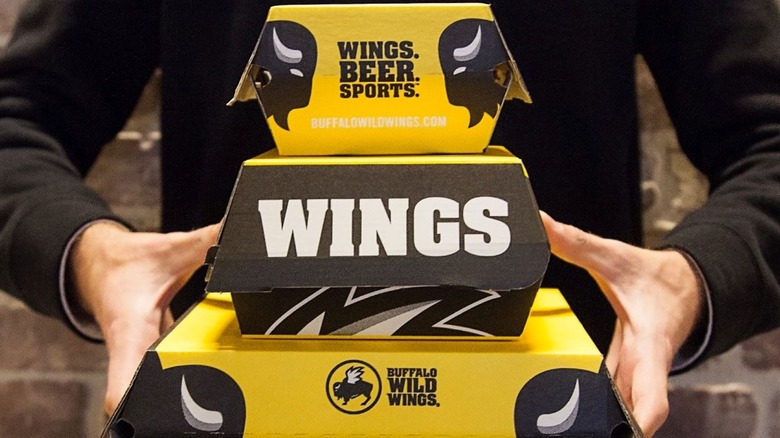 Person holding take out boxes from BWW