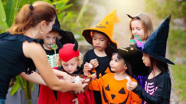 Unimpressed trick-or-treaters getting candy