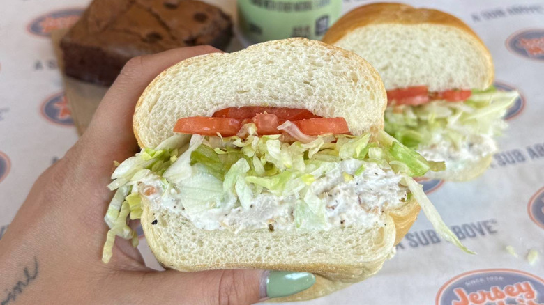 Jersey Mike's chicken salad sub with a drink and a brownie in the background