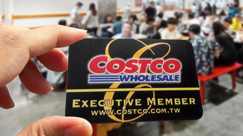 person holding costco membership card at the food court