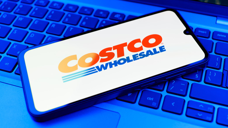 smartphone with costco app logo on top of computer keyboard
