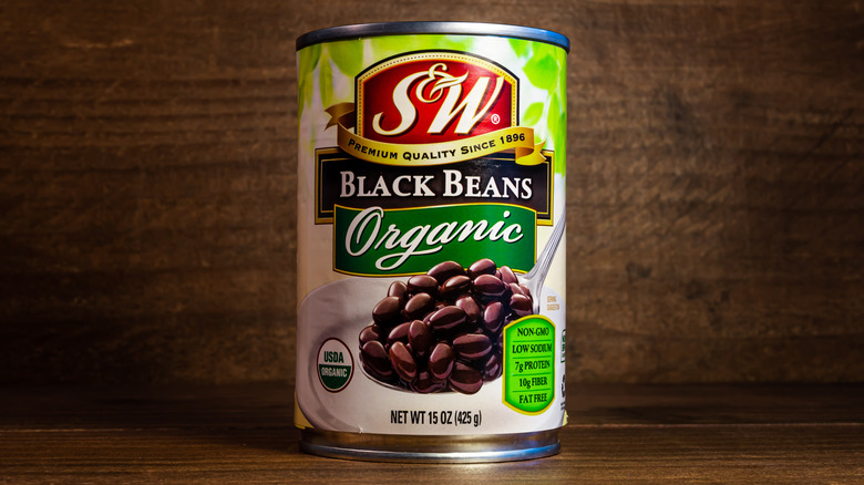 Can of S&W organic black beans against wooden background