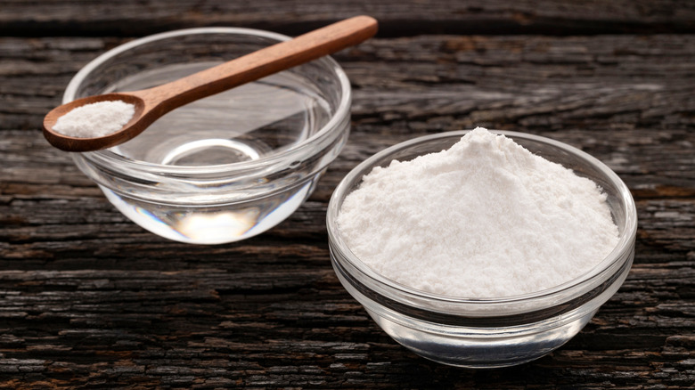 Glass bowl and wooden spoon filled with baking powder