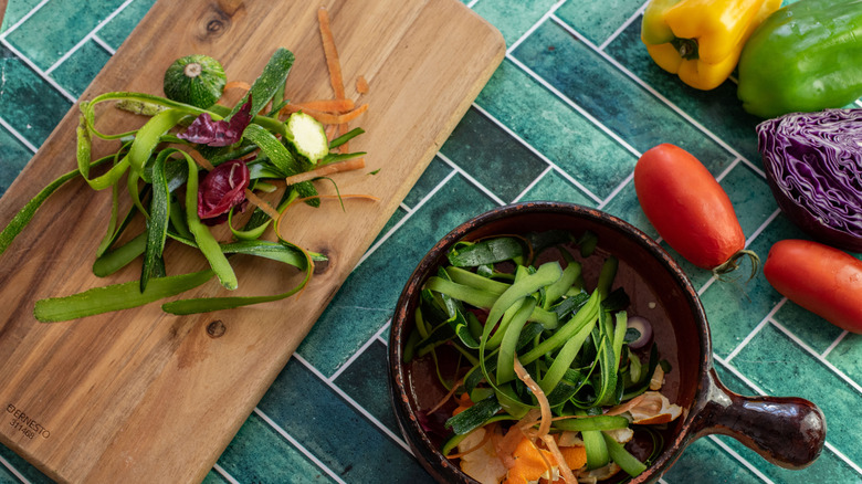 Food scraps on cutting board and in pot