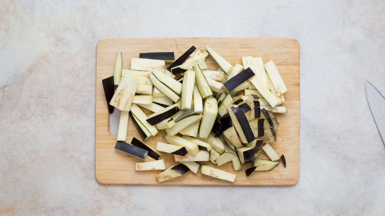 raw eggplant sticks on board