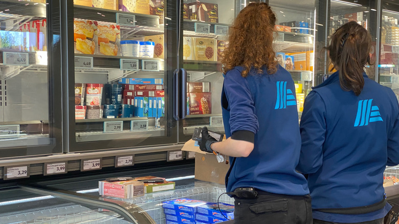 Two Aldi employees working side by side