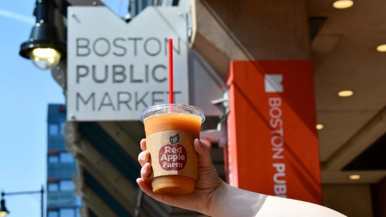 Red Apple Farm cider slushie in front of Boston Public Market Sign