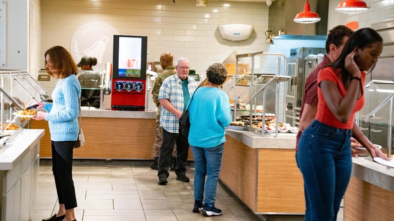 Customers selecting food inside buffet restaurant.