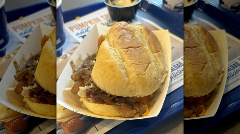 Culver's cod sandwich with grilled onions in paper dish on blue tray