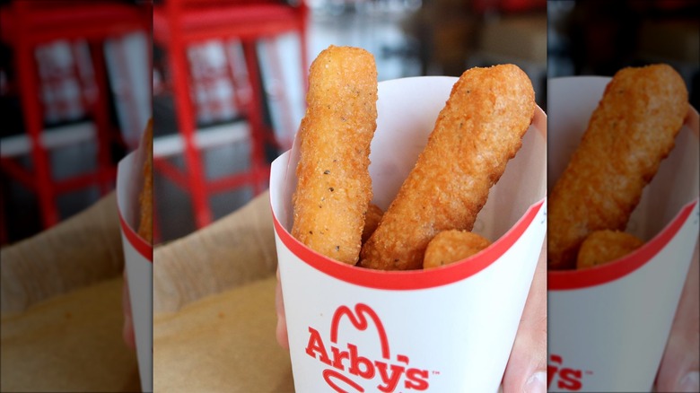 Person holding a carton of mozzarella sticks from Arby's.