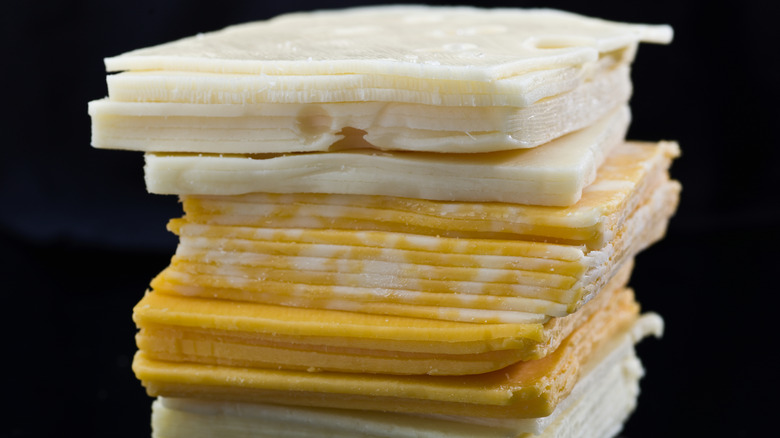 Stack of various sliced cheeses