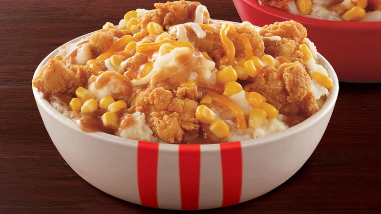 A KFC Famous Bowl with mashed potatoes, chicken, cheese, corn, and gravy.