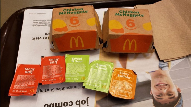 Chicken McNuggets and assorted sauces on tray in a McDonald's restaurant.