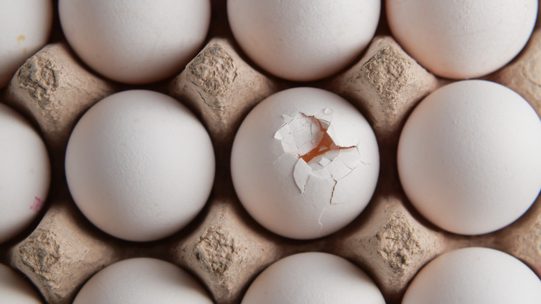 A cracked egg among eggs.