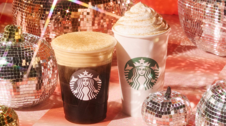 Two Starbucks pumpkin drinks surrounded by disco ball pumpkins.