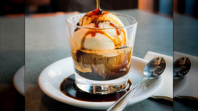 An affogato with ice cream and espresso in a small glass cup.