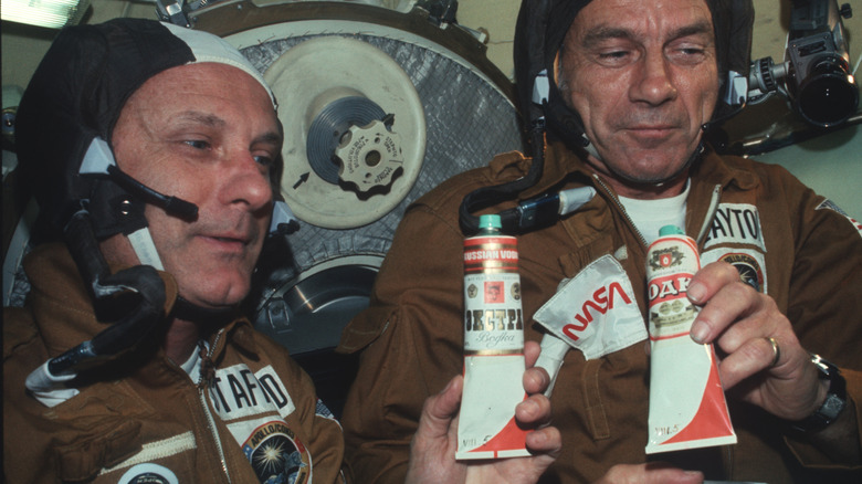 Apollo Astronauts Thomas P. Stafford and Donald K. Slayton holding vodka in food tubes.