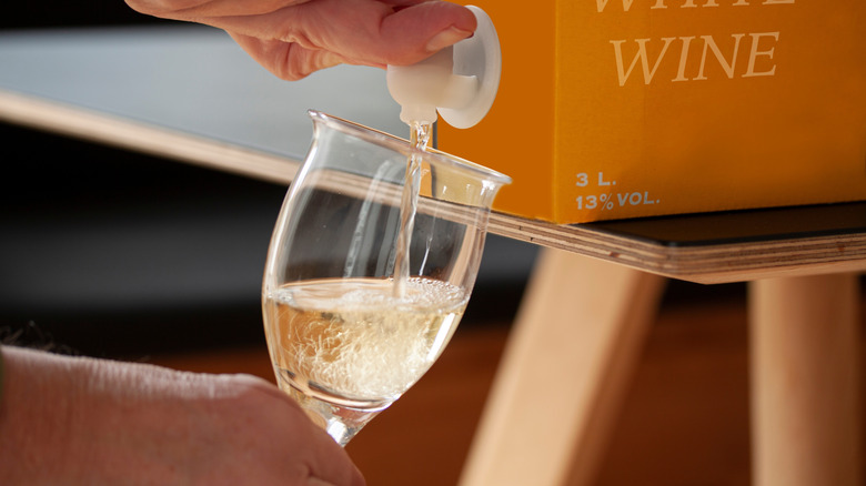 Pouring white wine from a box.
