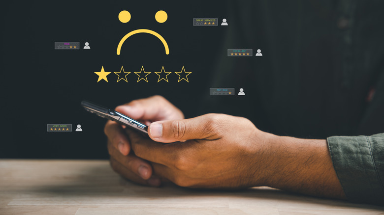 graphic depicting person posting a poor business review on their mobile phone