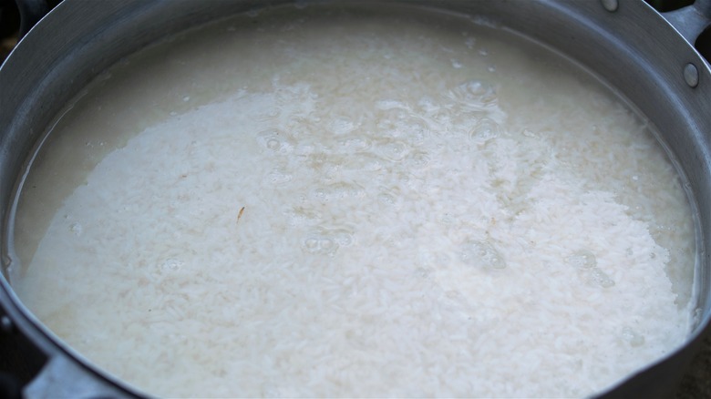 Undercooked rice in a pot that still has water.