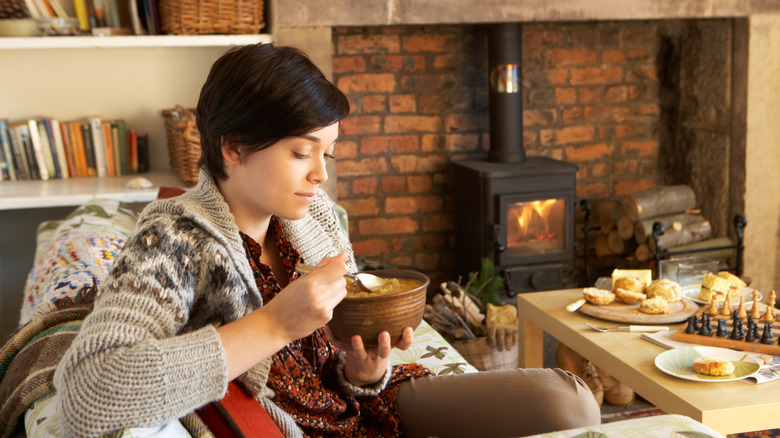 cozy woman eating soup