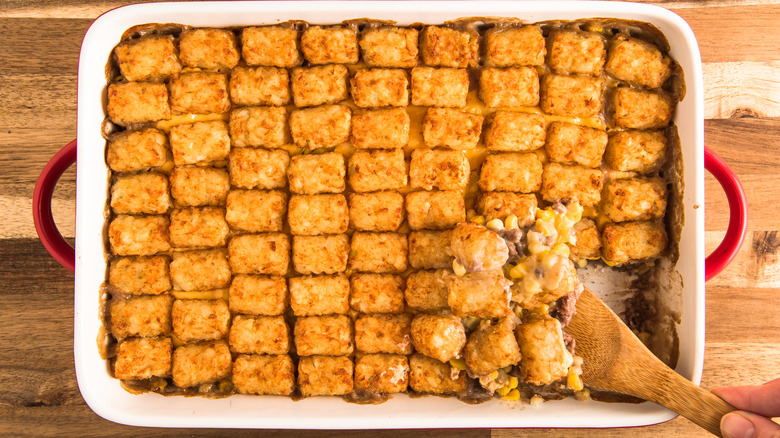 Casserole dish with browned tater tots in rows. 