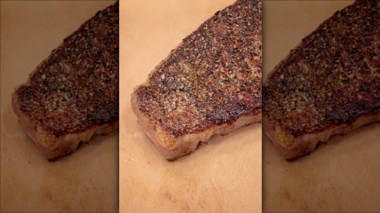 Closeup of evenly seared steak crust with salt and pepper