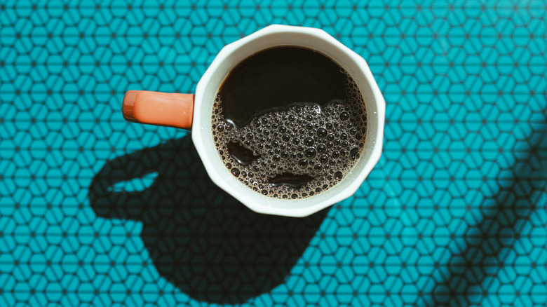 Overhead view of cup of black coffee.