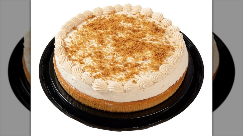 A round pumpkin flavored cheesecake on plastic tray.