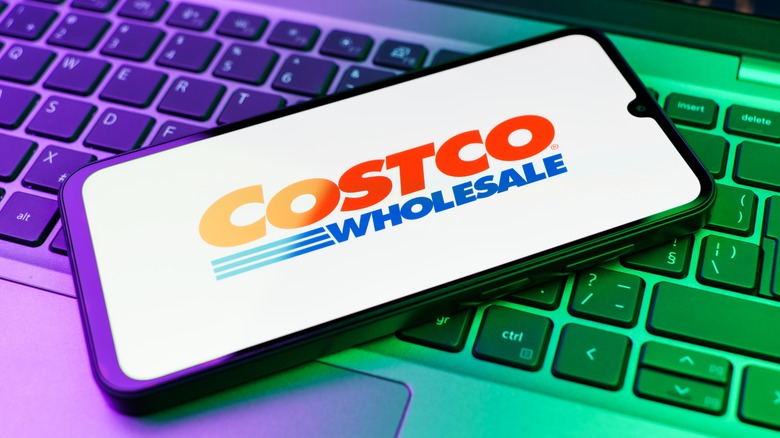 smartphone displaying Costco logo atop a keyboard