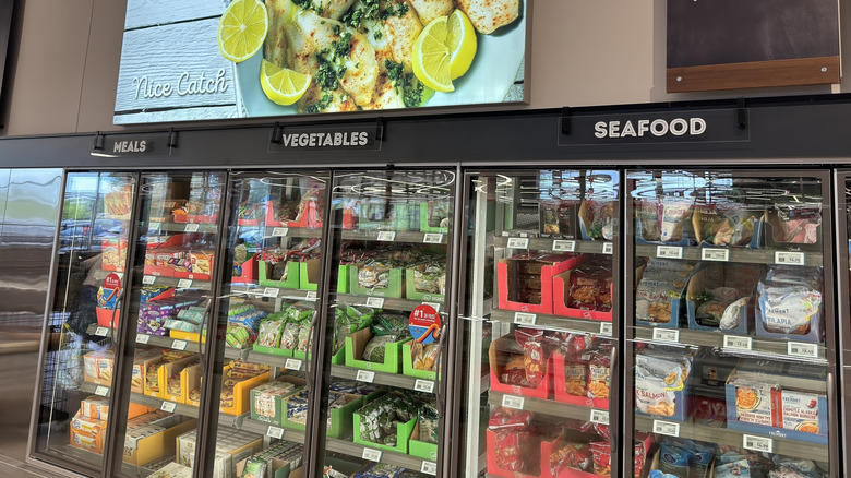 Refridgerated cases at Aldi displaying frozen meals, vegetables, and seafood.