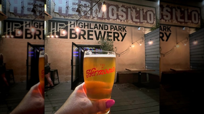 Hand holding a beer on the outdoor patio at the Hermosillo