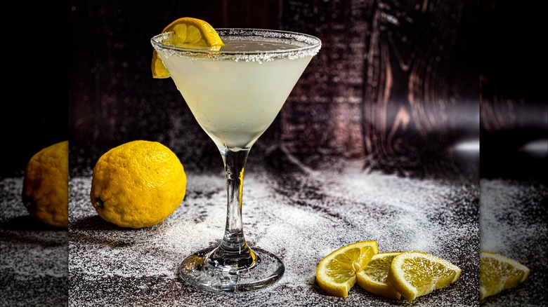 A lemon drop cocktail garnished with a lemon slice and a salt rim.