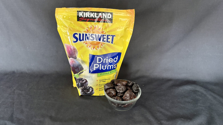 dried plums package behind bowl of dried plums