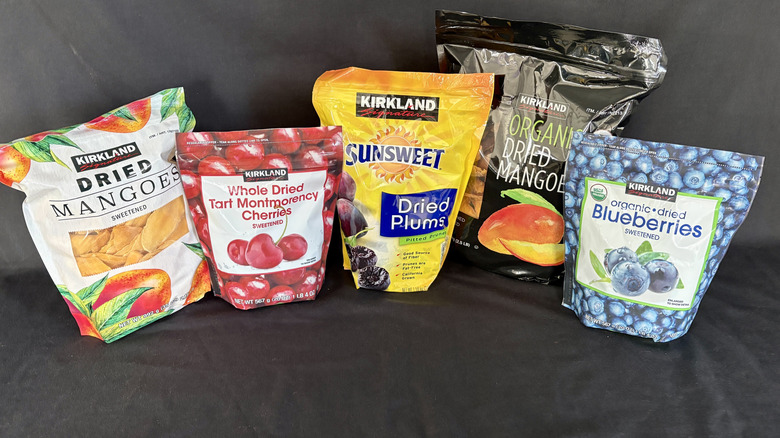 five bags of dried fruit on black background