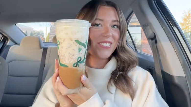TikTok content creator posing with drink from Starbucks