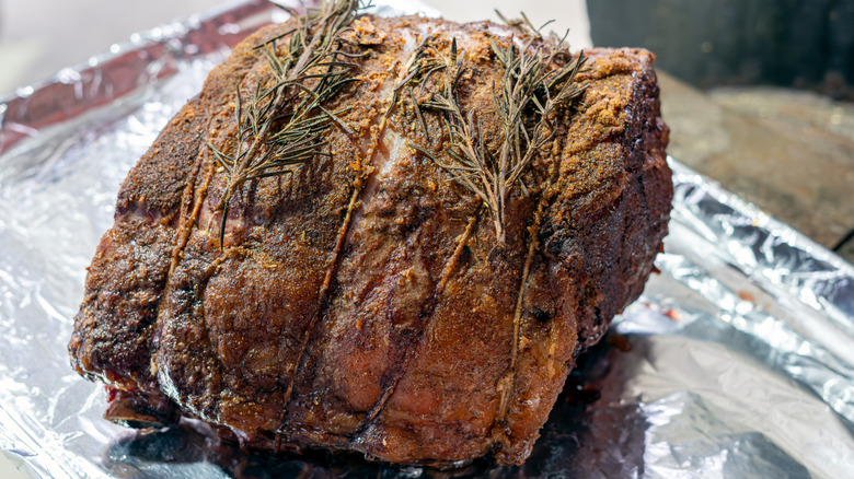A prime rib sitting on silver foil.