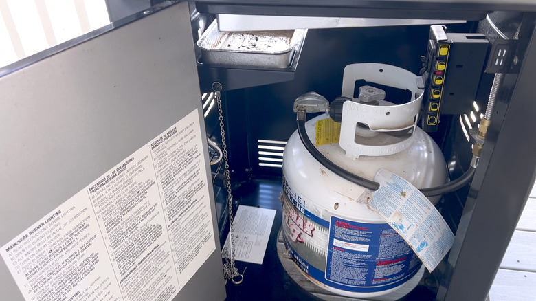 Propane tank attached to the inside of a propane grill