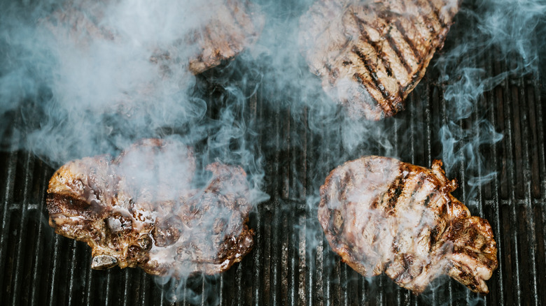 Steaks grilling and smoke from grill