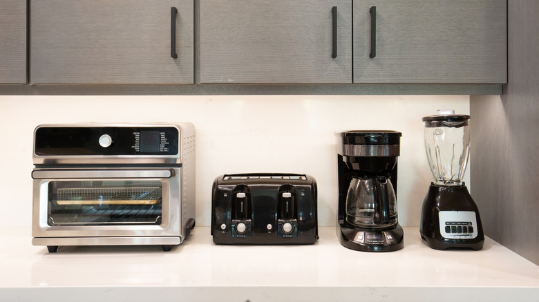 Air fryer convection oven, toaster, coffee maker, and blender on kitchen counter
