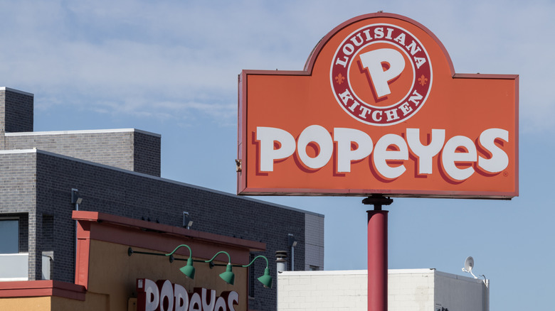 An orange sign for Popeyes Louisiana Kitchen outside a restaurant