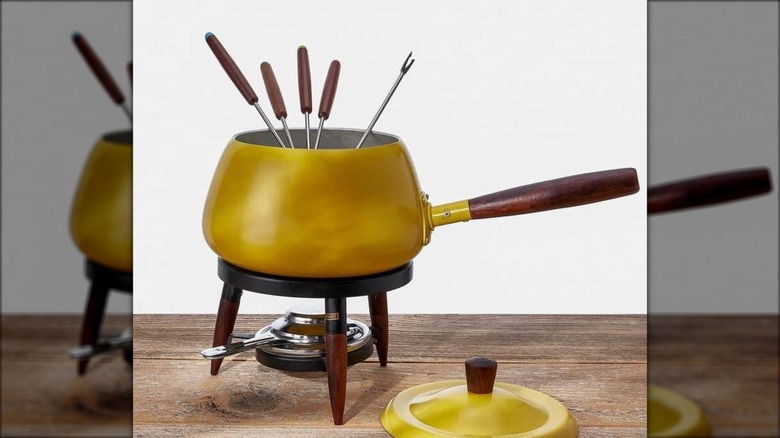 1960s harvest gold fondue set with pot, forks with wooden handles, burner, and lid