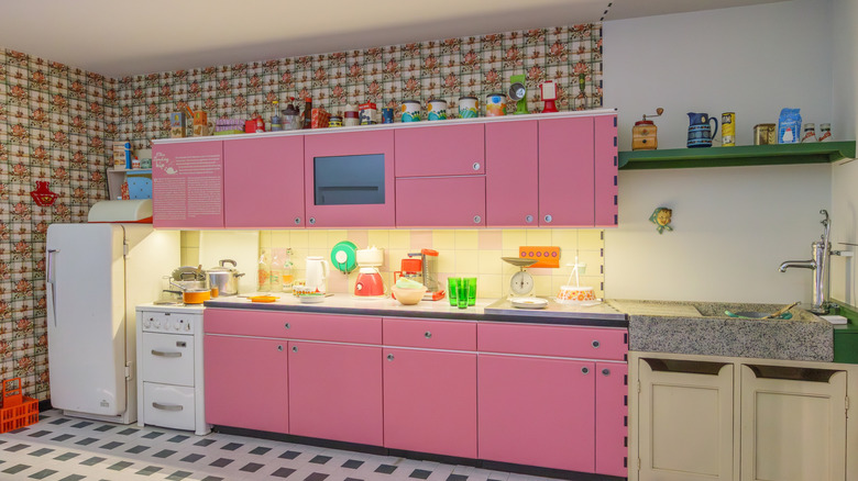 1960s kitchen with pink cabinets and abstract wall paper