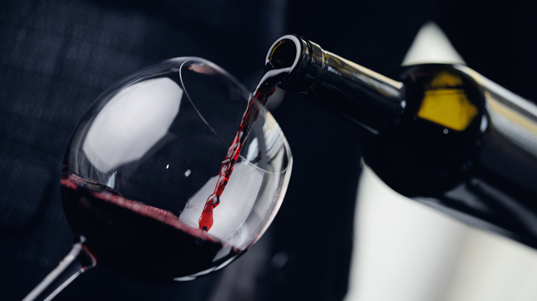 Pouring a glass of red wine from bottle