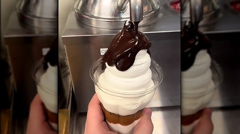 Dairy Queen Blizzard being made with cold fudge swirled on top