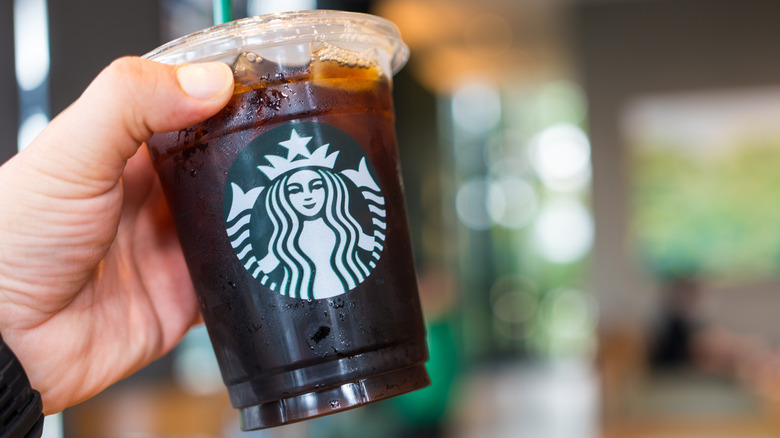 Hand holding Tall Starbucks cold brew.